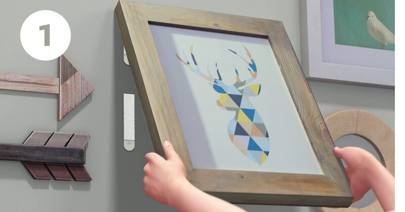 Step 1 of how to remove command picture hanging strips - grab bottom corners and peel frame from wall
